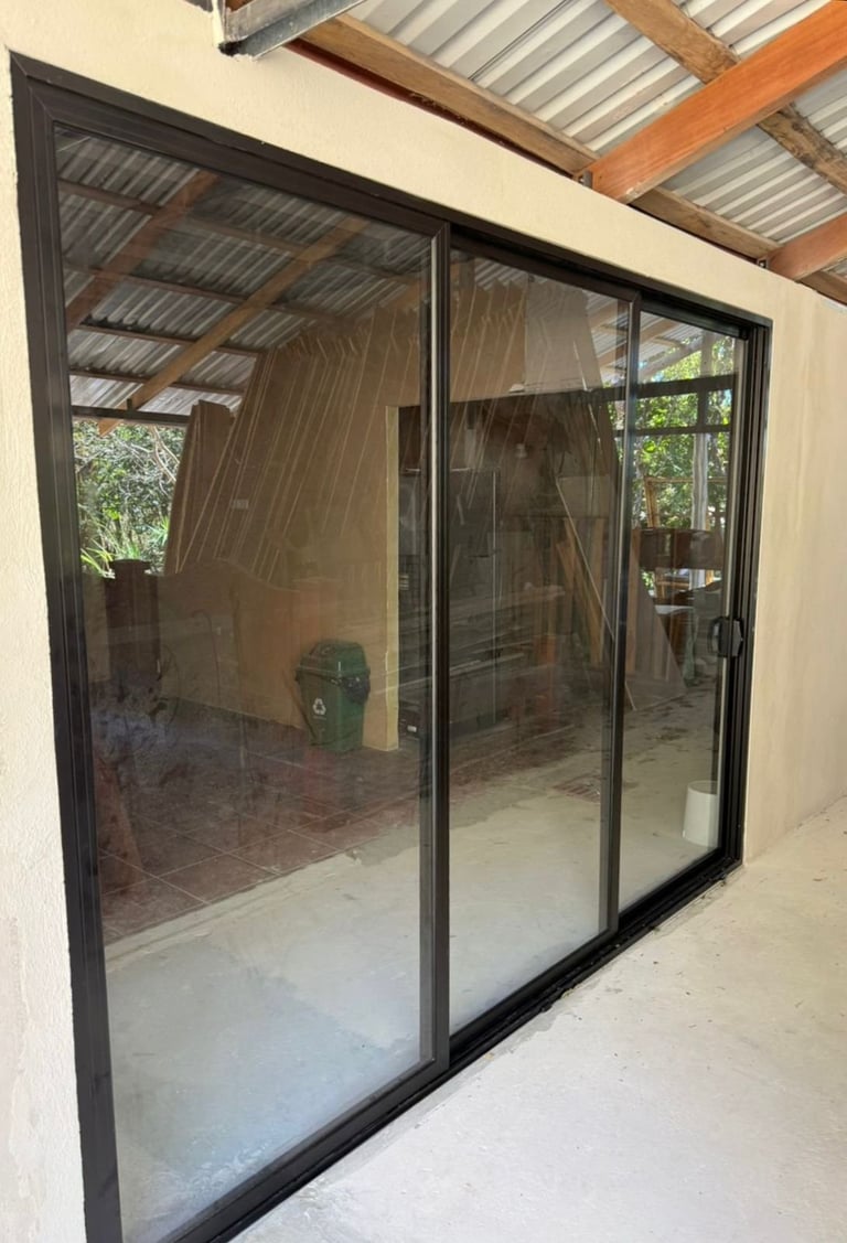 Puertas corredizas con paneles reflectivos en estructura moderna