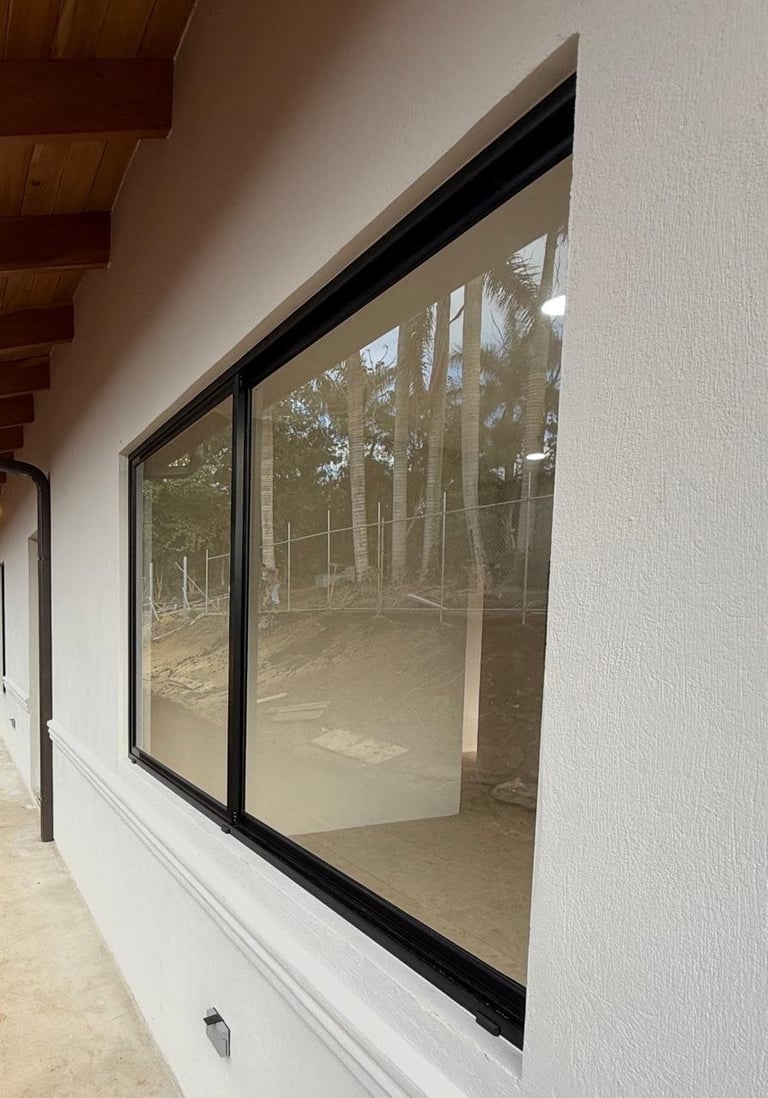 Puertas corredizas de vidrio con marco negro y vista al bosque