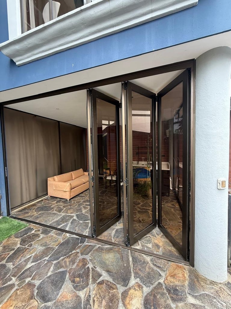 Casa moderna con puertas abatibles de vidrio hacia patio