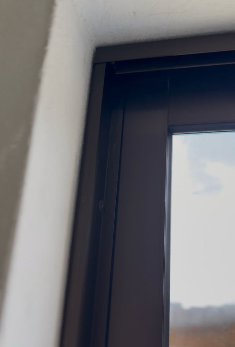 Ventana con marco oscuro y moldura blanca