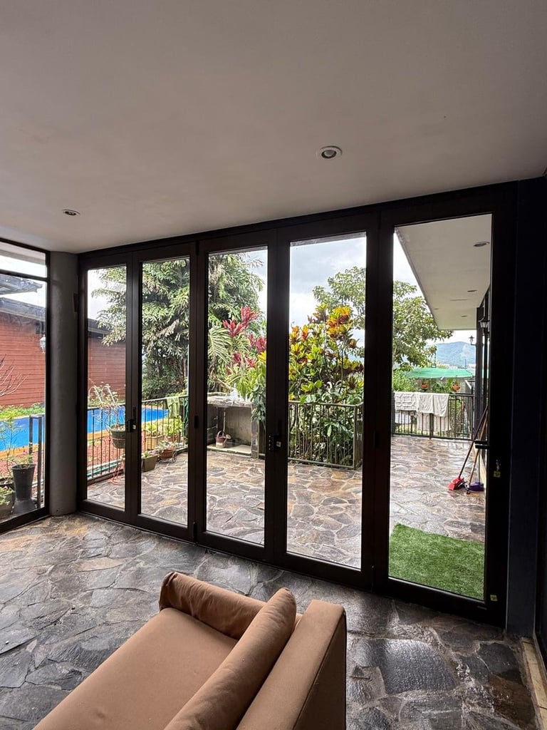 Sala moderna con puertas corredizas de vidrio hacia jardín