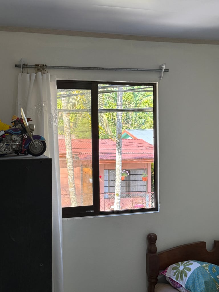 Interior con ventana grande y cortinas blancas