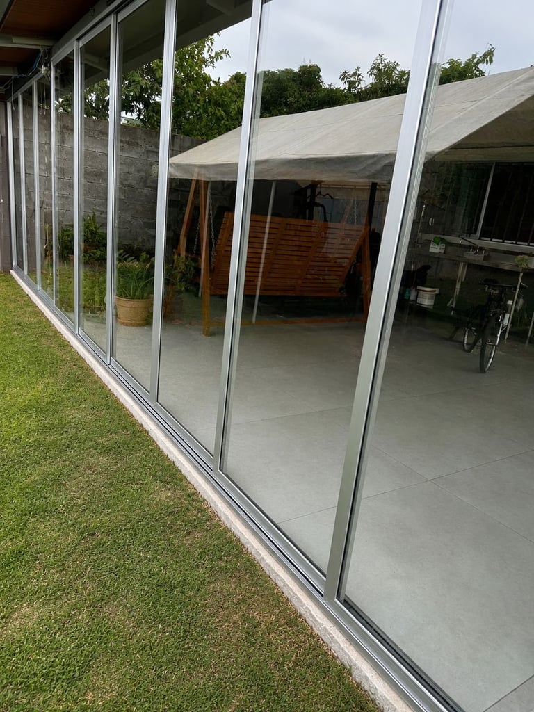 Patio moderno con puertas corredizas hacia jardín